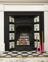 Living room detail showing fireplace with tiles and candles.