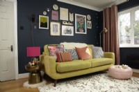 Living Room with a gallery wall and green sofa. With Christmas decoration details.