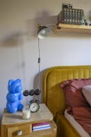 Designer lamp standing next to the yellow bed