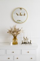 Detail of white sideboard with vase and candlestick