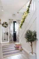 Front entrance hall and staircase with bannisters decorated with foliage and lights
