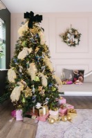 Christmas tree decorated with feathers and birds in a pink panelled living room