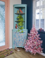 Hallway decorated for Christmas with a pink tree covered in baubles. The cabinet has been upcycled.