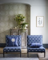 Blue patterned chairs in front of arched wallpapered alcove 