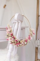 Detail of a dried flower hoop in a craft room hanging on the back of a chair