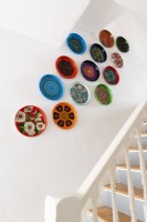 Display of painted trays on a staircase wall