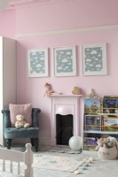 Pink painted walls and fireplace in childrens room