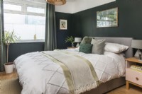 Modern bedroom with dark green painted walls