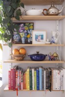 Accessories and cookbooks on kitchen shelves