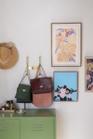 Detail of bedroom with handbags and artwork