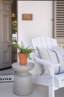 Detail of side table and Adirondack chair on entrance terrace