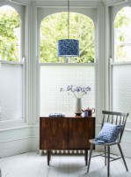 Patterned window film in bay window with midcentury furniture