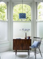 Patterned privacy film on bay window with midcentury modern furnitur.