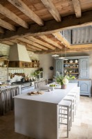 Modern white island and barstools in rustic country kitchen