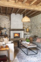 Country living room with lit fire at one end