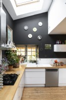 Modern kitchen with black painted walls and white units 