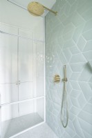 Pale grey tiling in modern white shower cubicle 