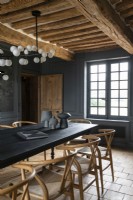 Grey painted walls and terracotta tiled floor in country dining room