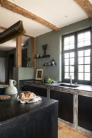 Contemporary country kitchen with green walls and black cabinets
