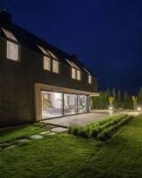 Night view from the garden to the house with illuminated interiors