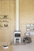 Small cream coloured wood burning stove in wooden living room