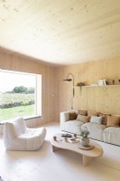 Wooden walls in country living room with picture window to garden