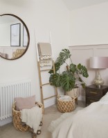 Master bedroom detail showing mirror, ladder, basket storage and pale pink panelling.