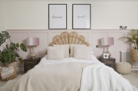 Master bedroom with pale pink panelling, a rattan headboard and soft furnishings.