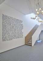 Writing on wall of minimal hallway with staircase 