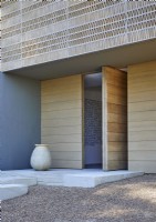 Exterior of contemporary house with open wooden front door 