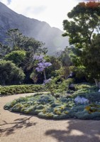 Tropical garden with brick pathway and view of mountains beyond