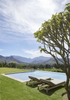 Swimming pool and gardens with mountain range in background