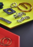 Detail of jewellery displayed on bright yellow tray