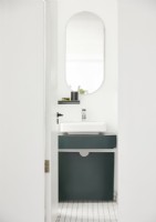 Green and white bathroom sink with large mirror