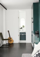Guitar in small open plan kitchen area with view to bathroom