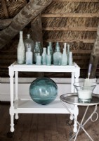 Collection of pale blue glassware on white trolley 