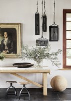 Unusual black box pendant lights in country hallway above sideboard