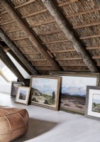 Display of classic landscape paintings on floor of country living space