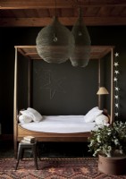 Simple wooden four poster daybed in black painted country bedroom
