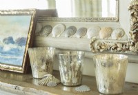Sea shells, votives and a coastal painting pay tribute to the cottage oceanic location.