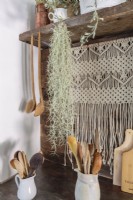 A macramÃ© hanging is unexpected and flirty as a backdrop to workaday kitchen tools.