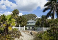 The exterior of the classic vintage Florida cottage was painted a pale green with contrasting white trim to reflect the local foliage and sandy beach.