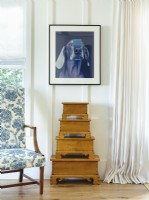 A dog portrait by one of Lindaâ€™s favorite artists, William Wegman, famous for his photographs and paintings of Weimaraner dogs, stands guard above a stack of little wooden trunks.