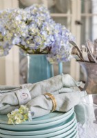 A palette of dusty blues introduces soft color to the table setting. Vintage linen napkins finish the elegant look.