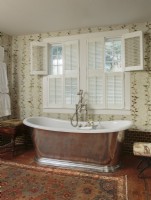 To satisfy a serious yearning for a glorious master bath, Ellen carved space from an adjacent bedroom to fit and feature this deep, old English-style soaking tub fashioned in polished tin and porcelain. 