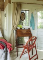 I you are looking for a quiet a spot to work on your novel, this little nook outfitted with an antique writing desk awaits. The first item the couple bought for the tree house was a diminutive antique oak secretary, which folds up when not in use. Just the perfect spot to write your novel!