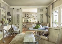 Once walled off from both the kitchen and living area, this sunny space plays dual roles as a dining room and a library. Antique French entry doors are suspended on tracks and wheelsâ€” barn door styleâ€”that are hidden by added-on crown molding. Doors are pull closed when needed but when left open guests can see the back kitchen walls from the front entry. 