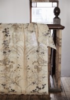 Cream patterned fabric draped over bannisters of wooden staircase