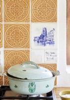 Cooking pot on gas burner in country kitchen with decorative tiles