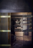 Gold railing doors to classic walk in wardrobes with black walls